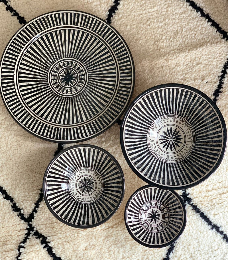 A set of three stunning and intricate black and white bowls and a plate